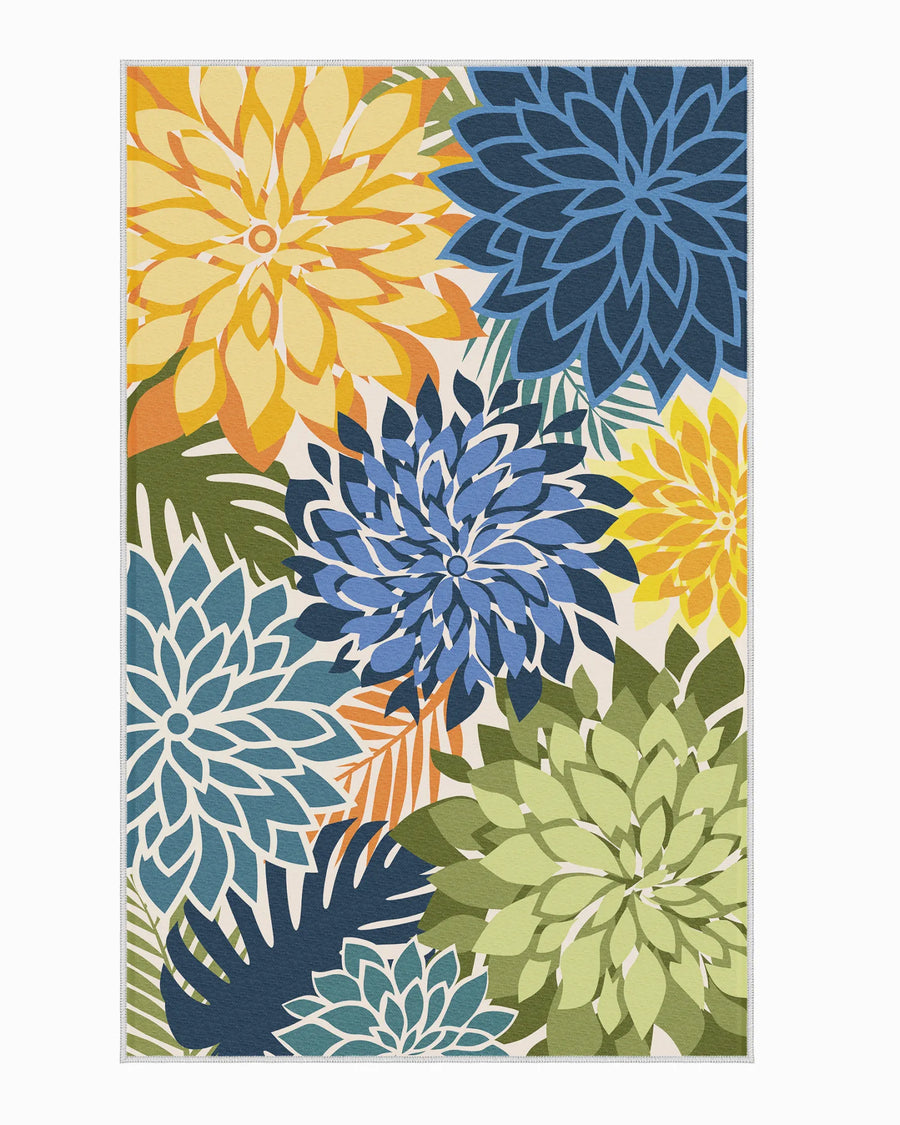 Floral outdoor rug with oversized blue, yellow, and green dahlia pattern