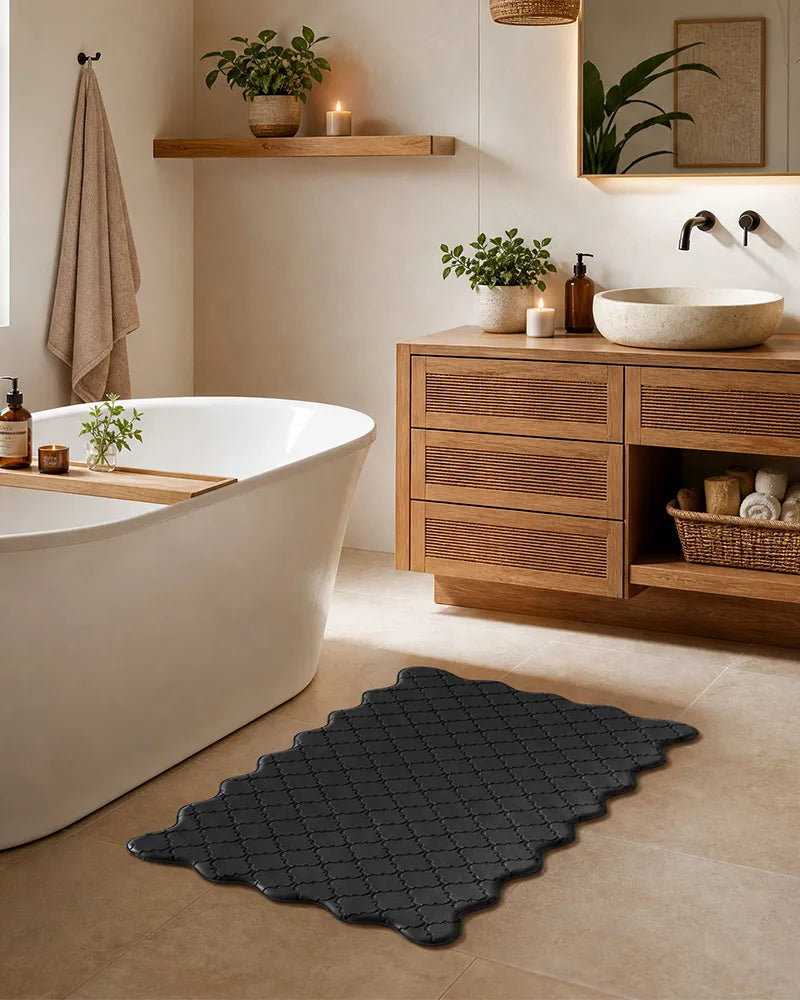 Black scalloped anti-fatigue floor mat beside a bathroom vanity