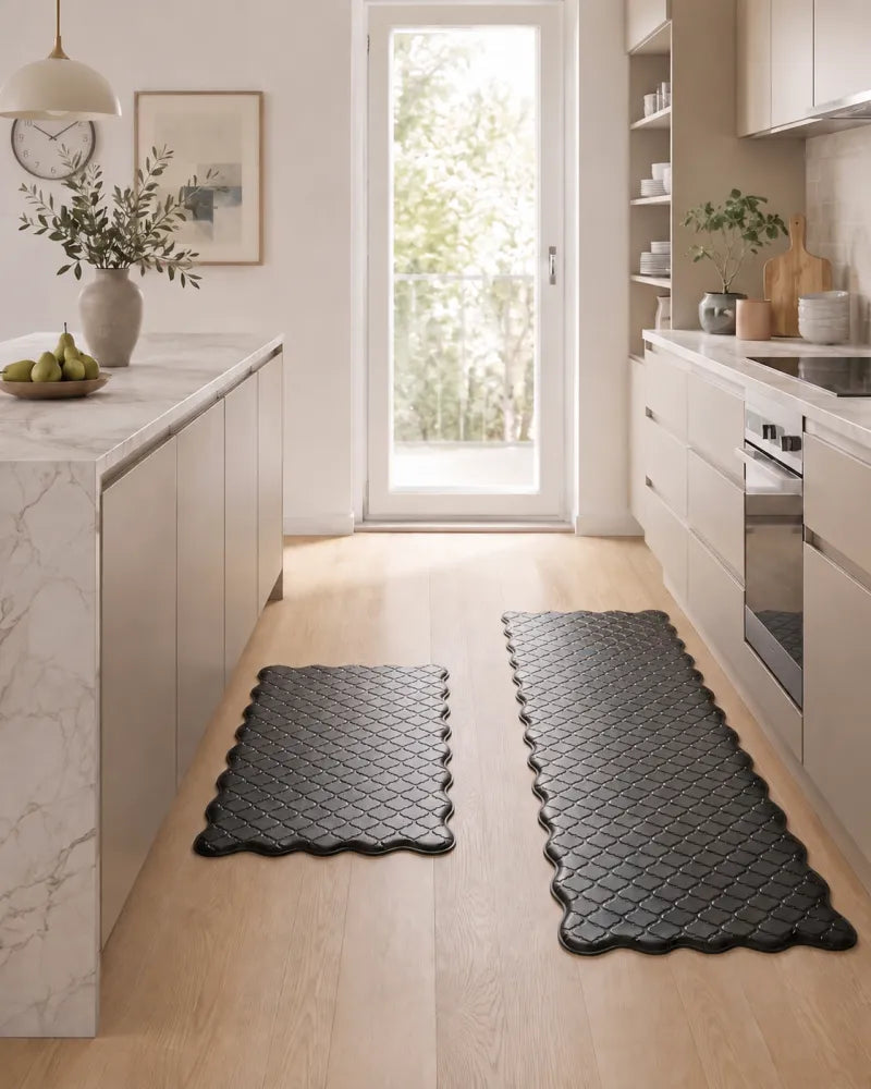 Black scalloped anti-fatigue kitchen mat set in a bright modern kitchen with white cabinets