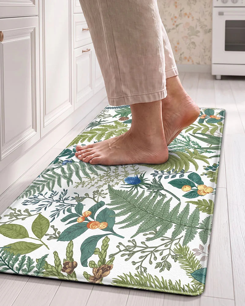 Bare feet standing on a Creamy White cushioned botanical kitchen mat