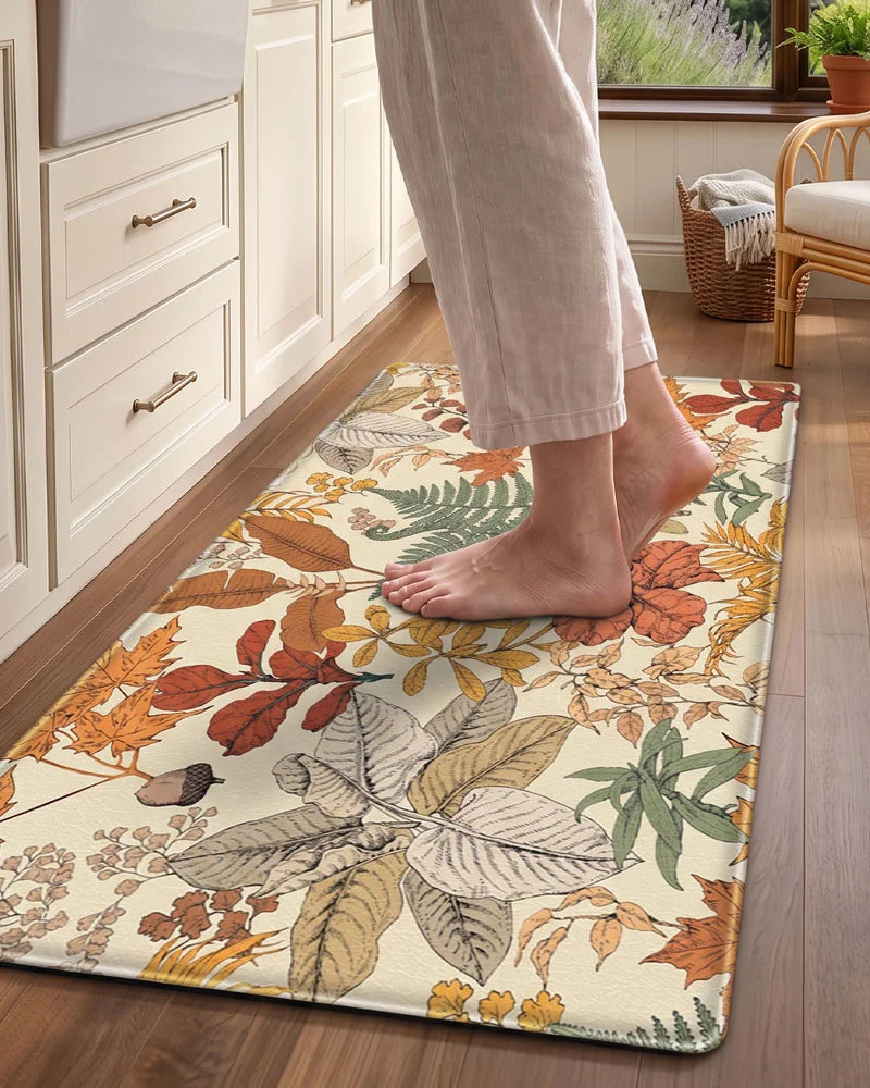 Bare feet standing on a Maple Orange cushioned botanical kitchen mat