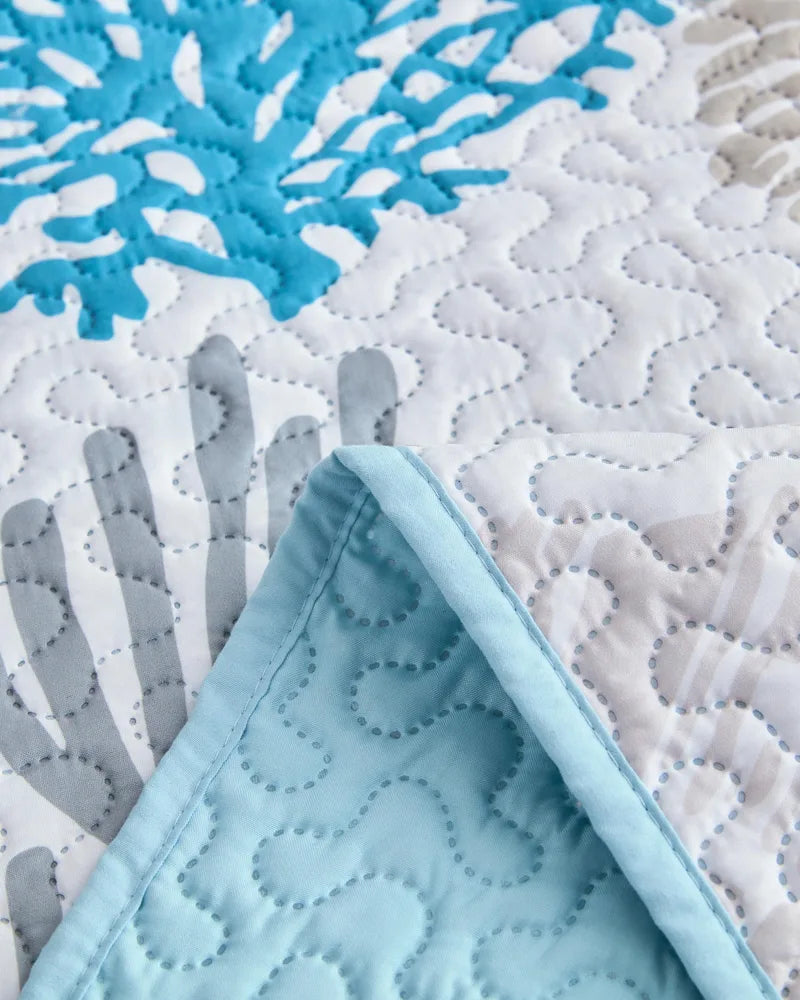 Close-up of coastal quilt stitching and blue coral and starfish print