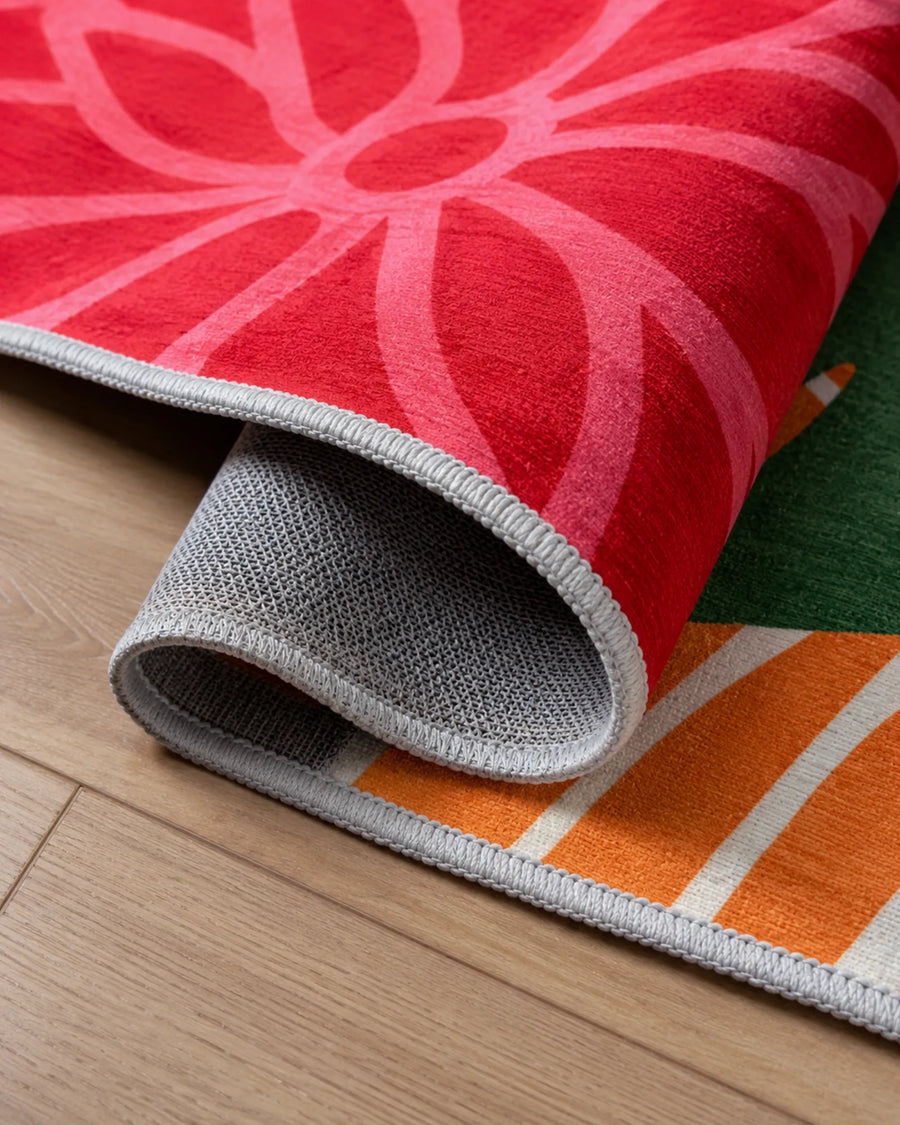 Floral outdoor rug closeup showing soft chenille texture, bound edge, and non-slip backing