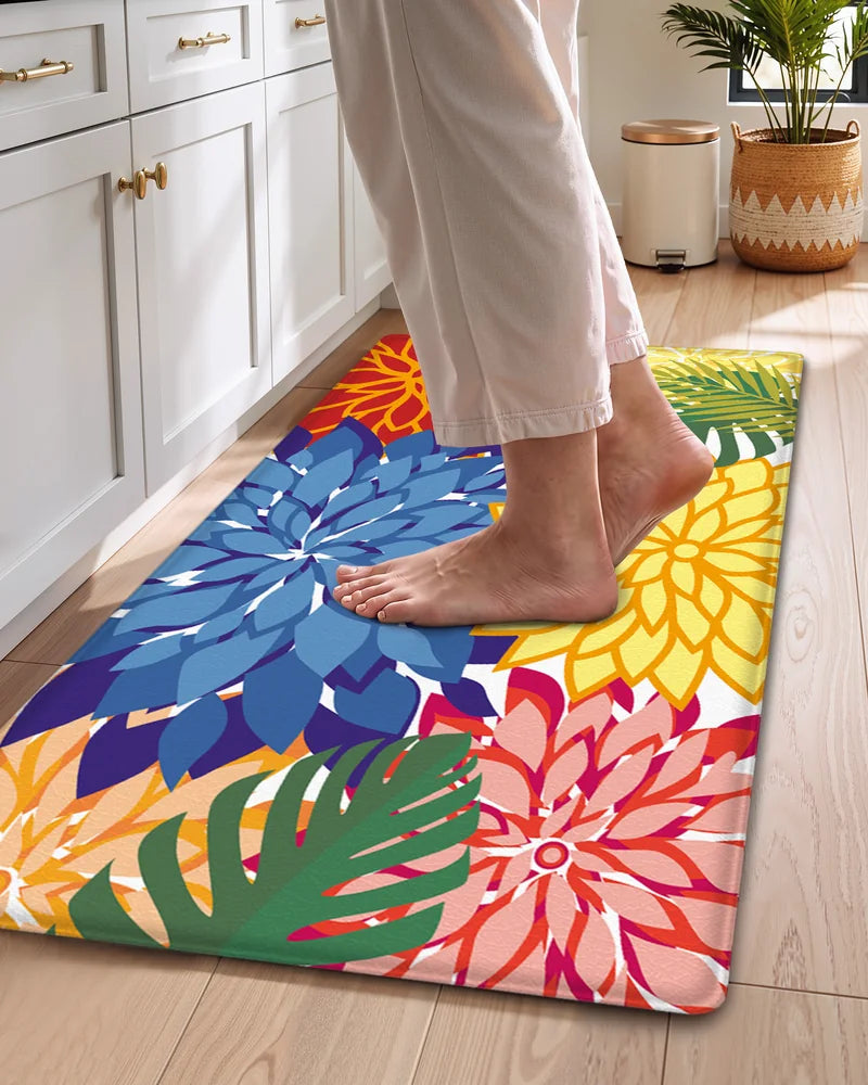 Bare feet standing on a colorful floral cushioned anti-fatigue kitchen mat
