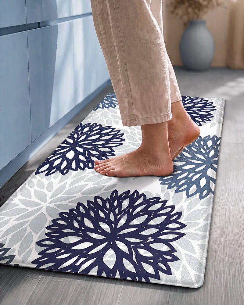 Bare feet on a Navy Teal cushioned dahlia floral anti-fatigue kitchen mat