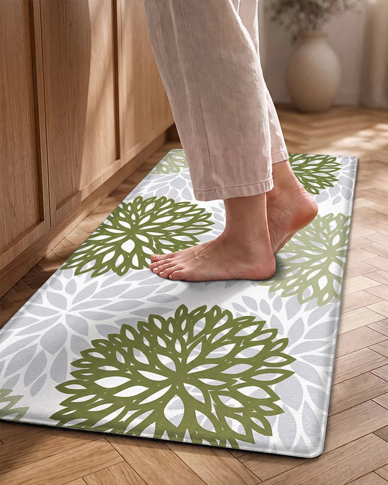 Bare feet on a Sage Green cushioned dahlia floral anti-fatigue kitchen mat