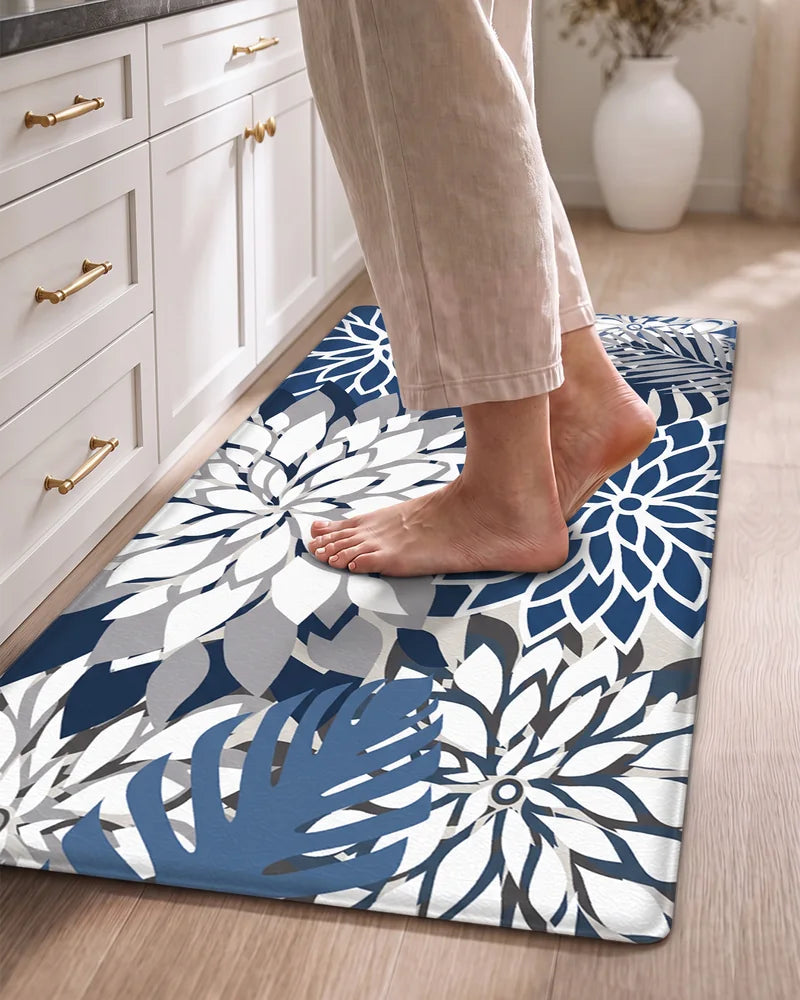 Bare feet standing on a Blue Gray floral cushioned anti-fatigue kitchen mat