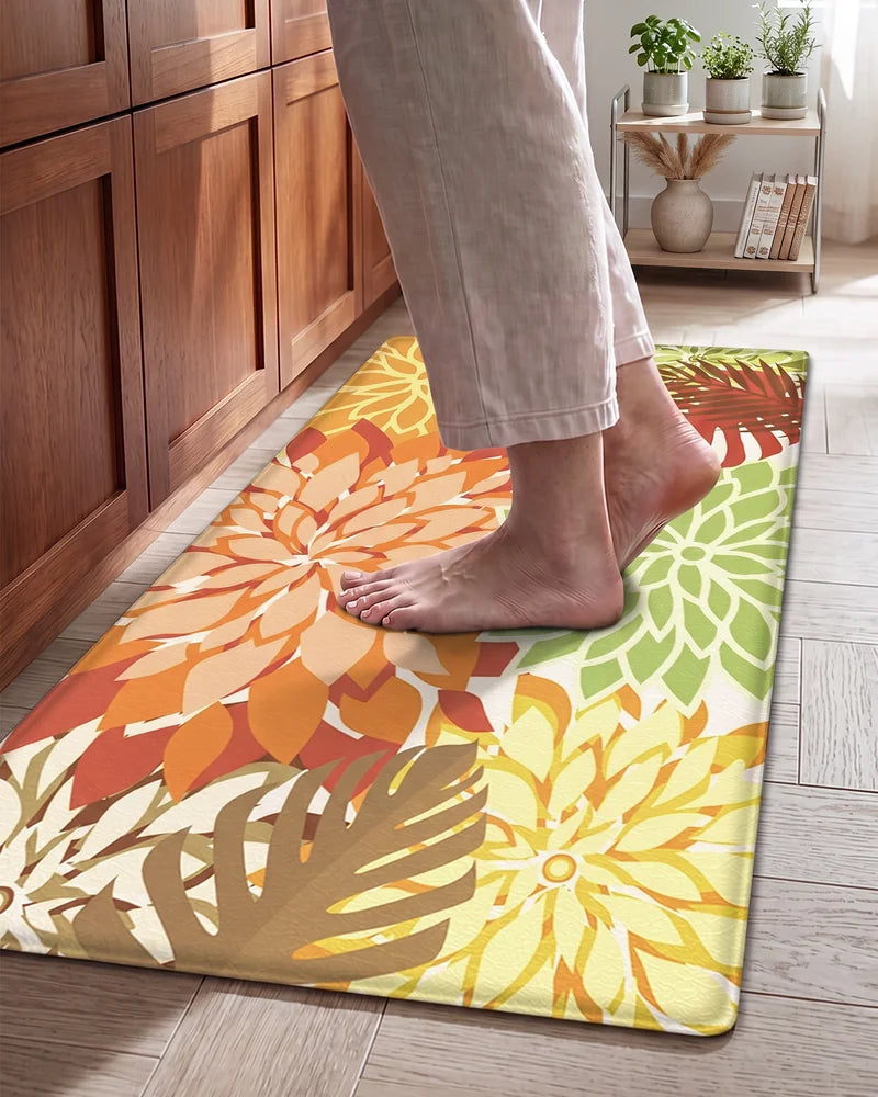 Bare feet standing on a Maple Orange floral cushioned anti-fatigue kitchen mat
