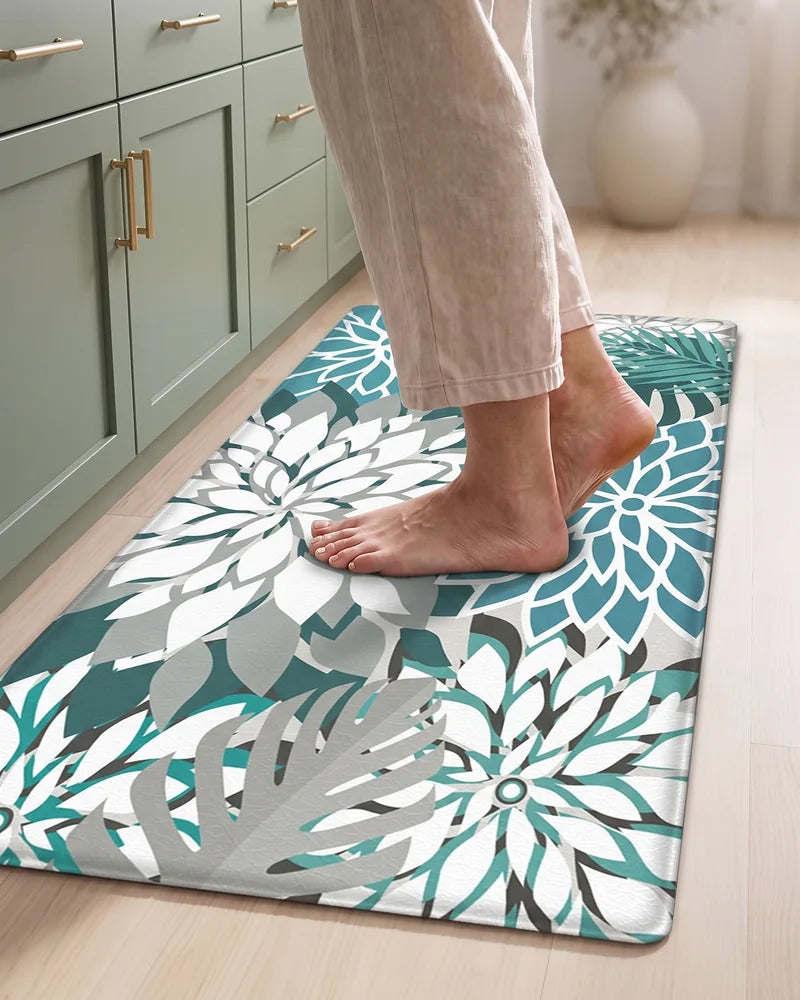 Bare feet standing on a Teal floral cushioned anti-fatigue kitchen mat
