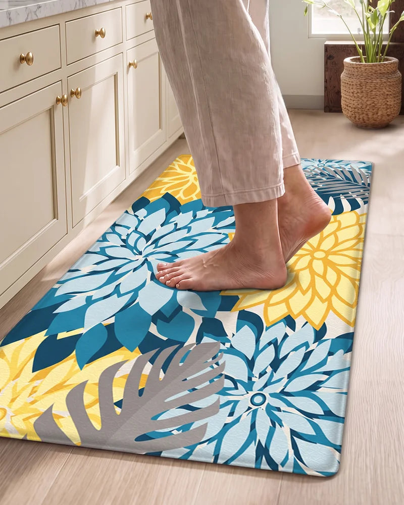 Bare feet standing on a Yellow Teal floral cushioned anti-fatigue kitchen mat