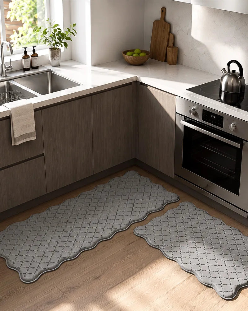 Gray scalloped anti-fatigue kitchen mat set beside dark cabinets