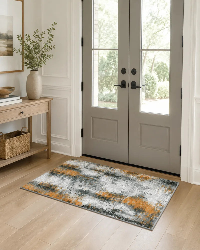 Orange washable abstract foyer rug beside gray double doors