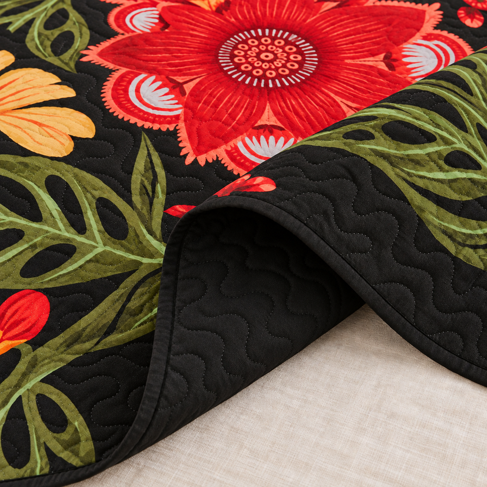 Flore quilt in Crimson Shadow folded to reveal its black reverse, bound edge and red floral print.