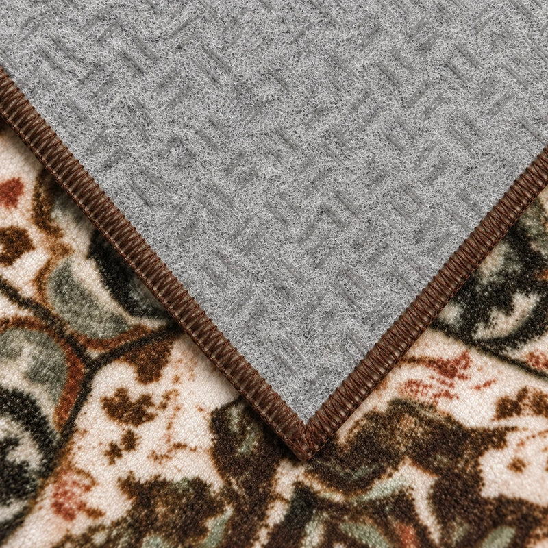 Gray textured non-slip backing and brown stitched edge on a folded vintage boho kitchen rug