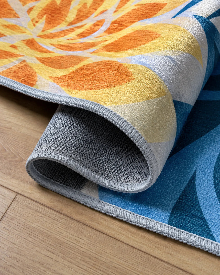 Floral outdoor rug closeup showing chenille texture, bound edge, and non-slip backing